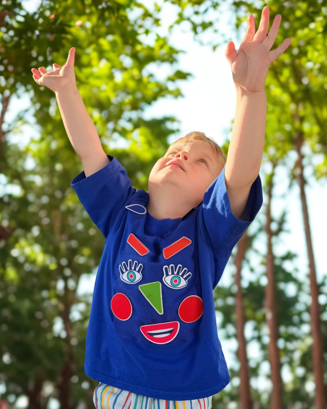 Child playing in a blue TeeBoo™ interactive kids T-shirt with the Moody Friends BooPatch™ set for creative screen-free play.