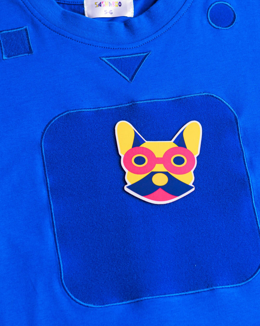 Close-up of the blue TeeBoo™ interactive kids T-shirt featuring the signature French Bulldog patch by SASHABOO.