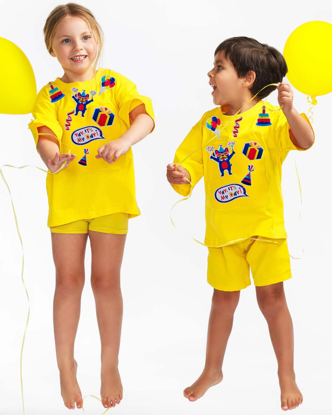 Kids wearing yellow TeeBoo™ Interactive Kids Gift Set with Yay, It's My Day! BooPatch™ pieces for screen-free imaginative play.