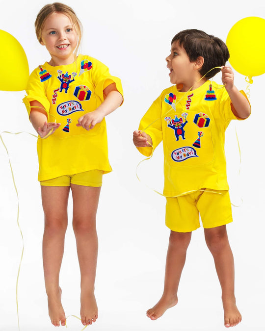 Kids wearing yellow TeeBoo™ Interactive Kids Gift Set with Yay, It's My Day! BooPatch™ pieces for screen-free imaginative play.