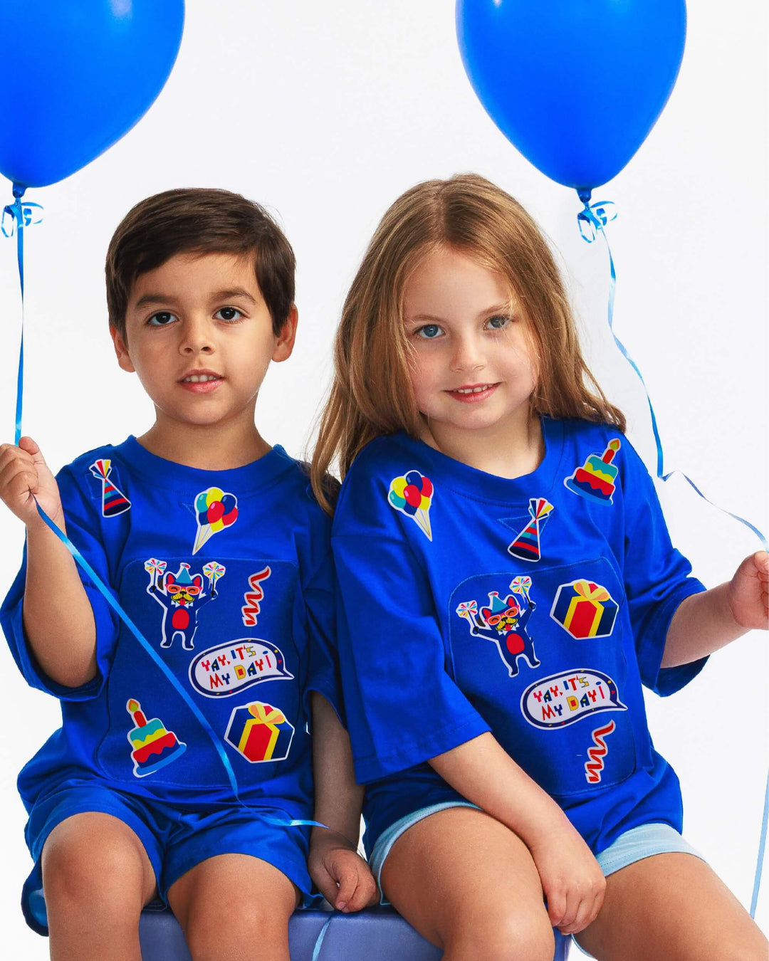Boy and girl wearing blue TeeBoo™ Interactive Kids Gift Set with Yay, It's My Day! BooPatch™ pieces for creative play.