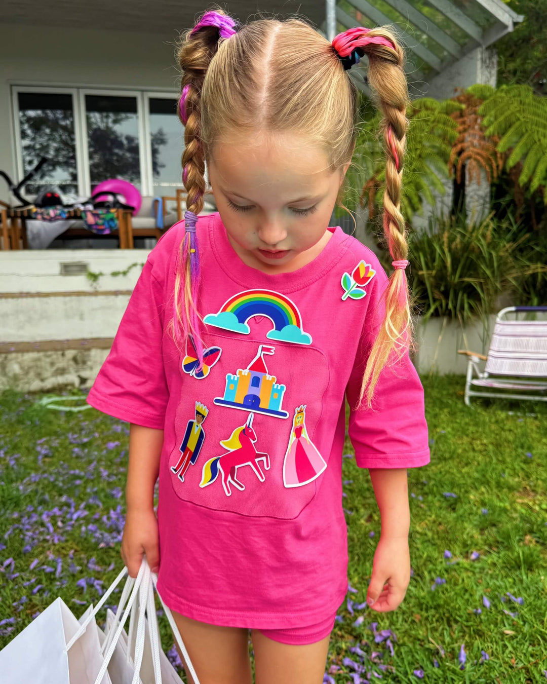 Girl wearing a pink TeeBoo™ interactive kids T-shirt with the Fairy Sparkle BooPatch™ set during outdoor play.