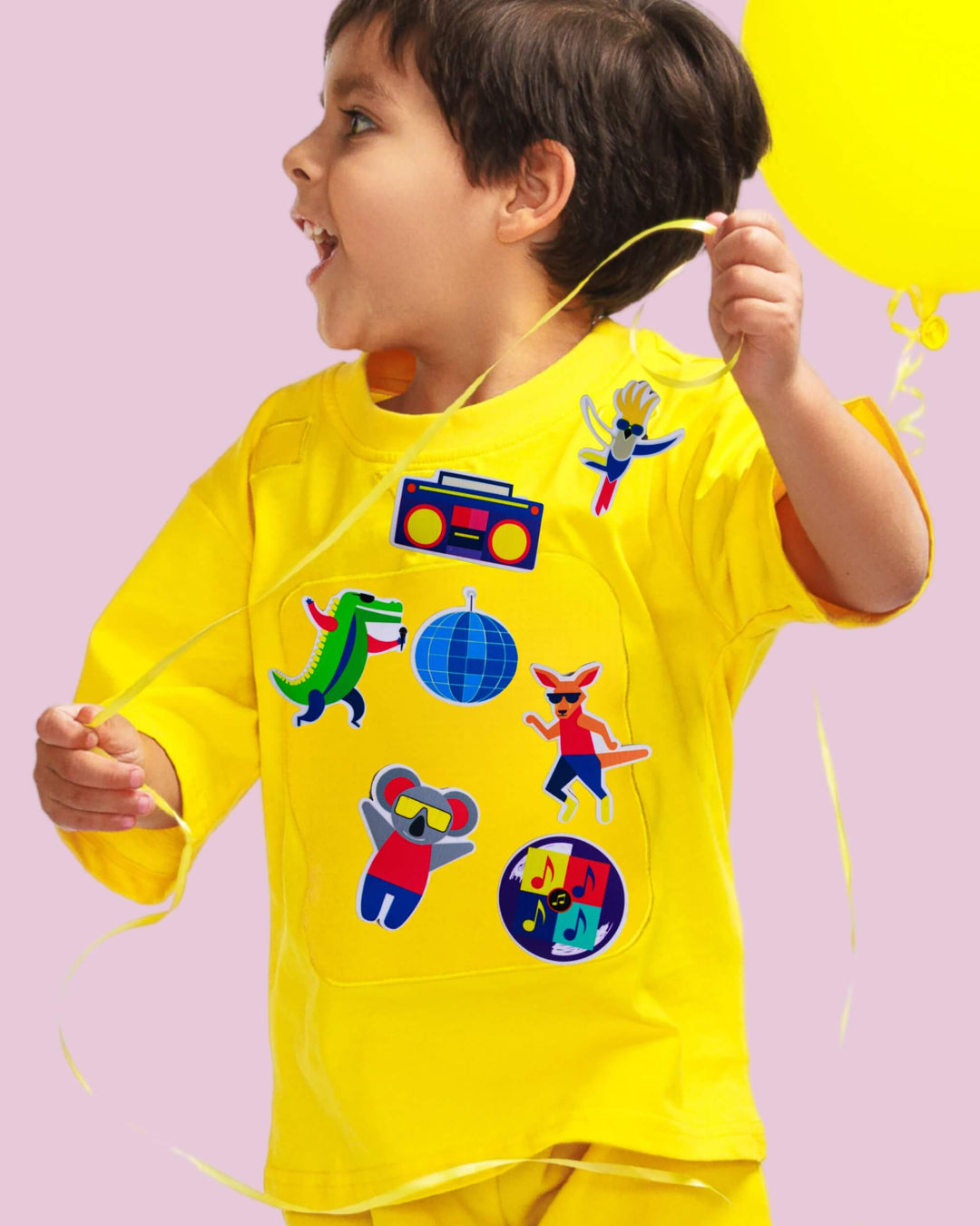 Child wearing a yellow TeeBoo™ interactive kids T-shirt with the Aussie Animals Disco BooPatch™ gift-ready set.