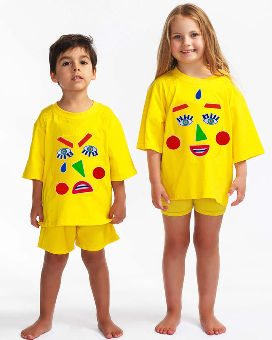 Boy and girl wearing a yellow TeeBoo™ interactive kids T-shirt with the Moody Friends BooPatch™ gift-ready set for screen-free play.