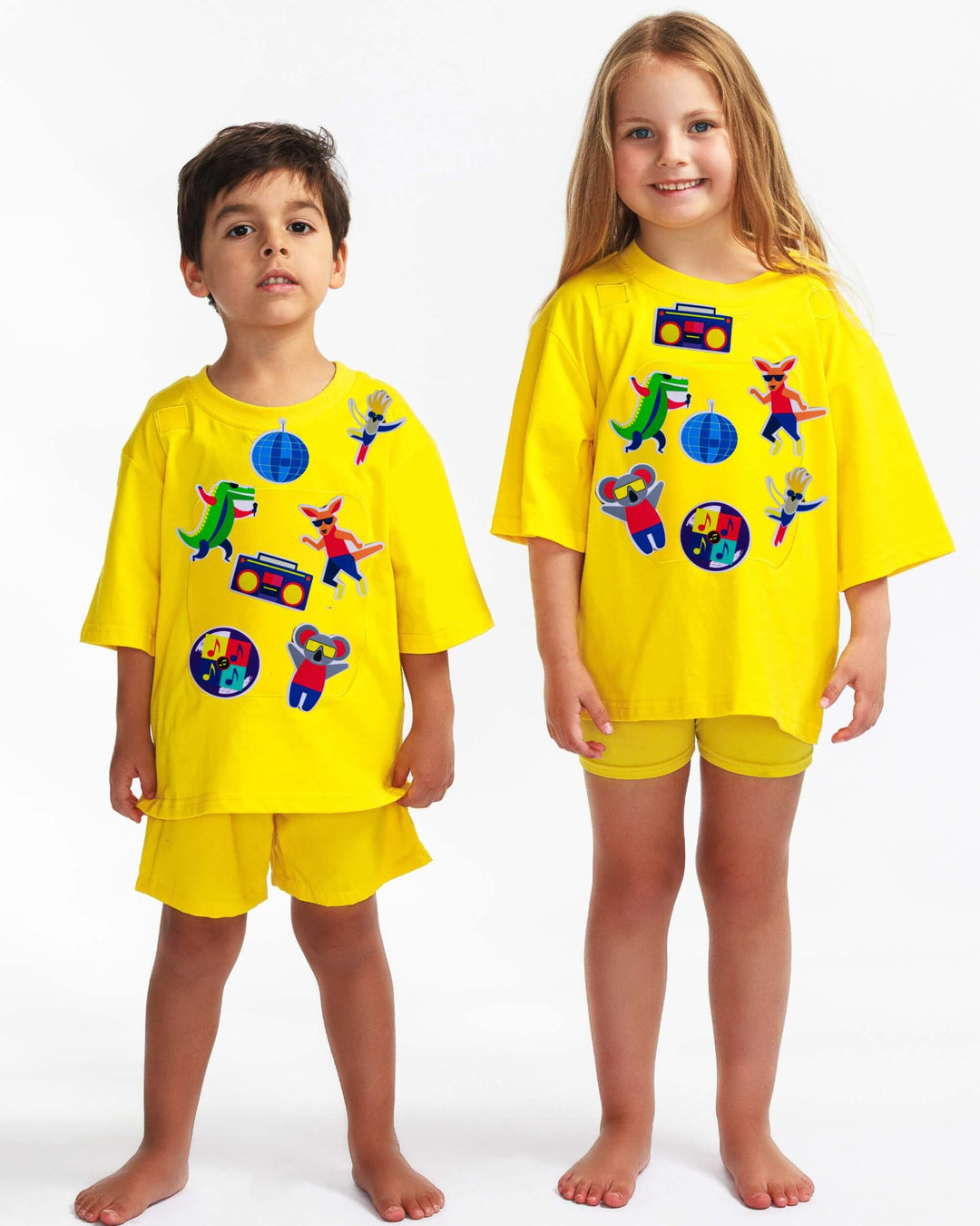 Boy and girl wearing a yellow TeeBoo™ interactive kids T-shirt with the Aussie Animals Disco BooPatch™ gift-ready set.