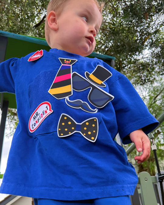 Boy playing in a blue TeeBoo™ interactive kids T-shirt with the Mr. Confident BooPatch™ set outdoors.