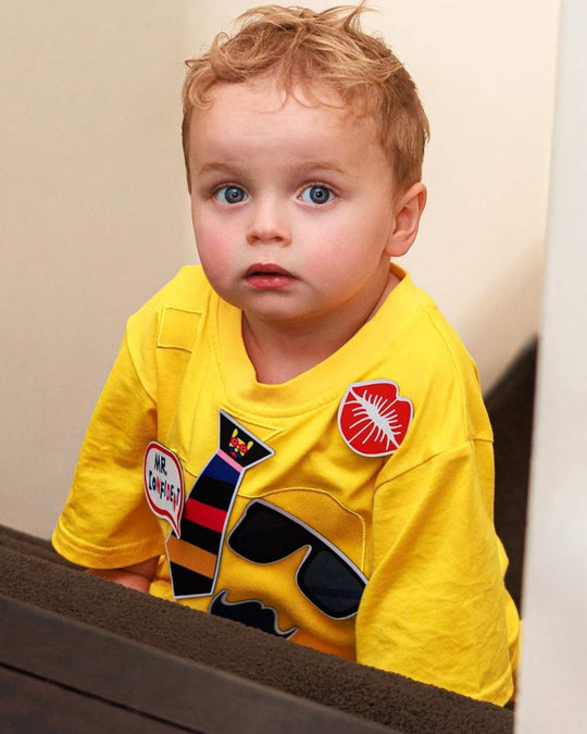Toddler wearing a yellow TeeBoo™ interactive kids T-shirt with the Mr. Confident BooPatch™ gift-ready set.