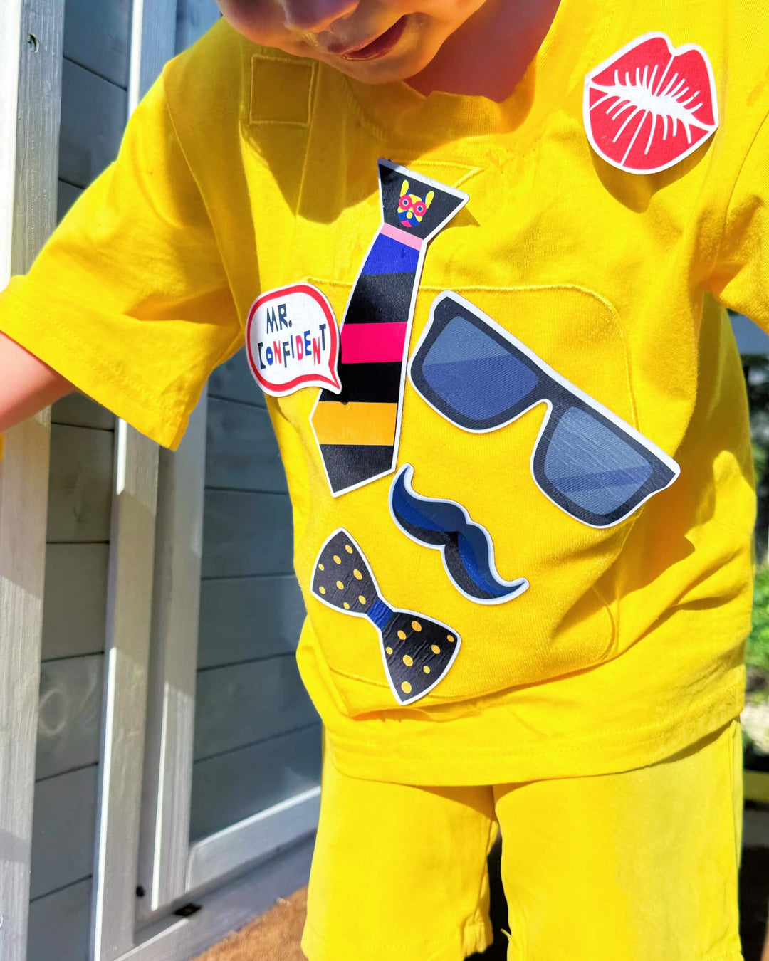 Child wearing yellow TeeBoo™ Interactive Kids Gift Set with Mr. Confident BooPatch™ pieces for imaginative, screen-free play.