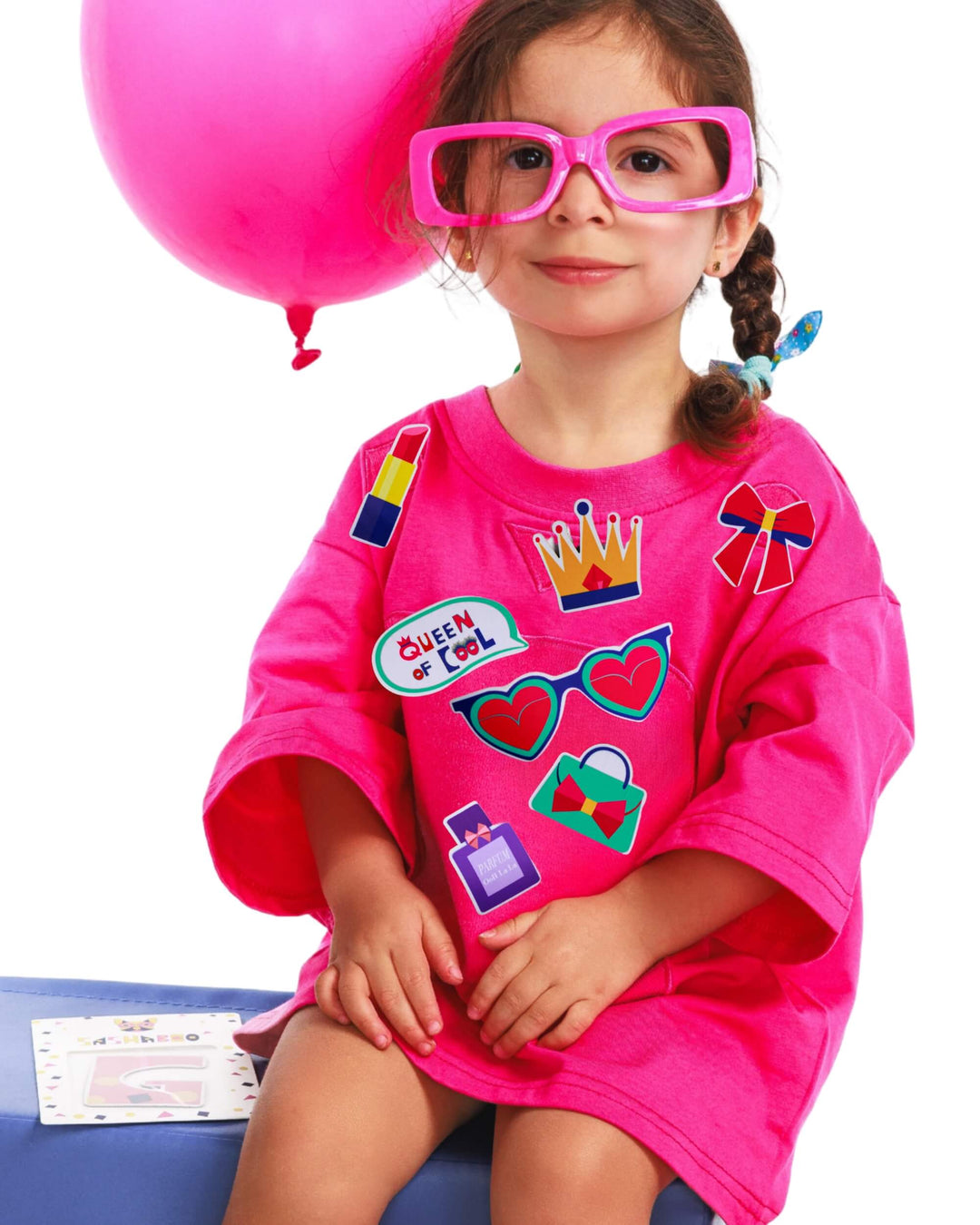 Girl wearing a pink TeeBoo™ interactive kids T-shirt with the Queen of Cool BooPatch™ gift-ready set for imaginative screen-free play.