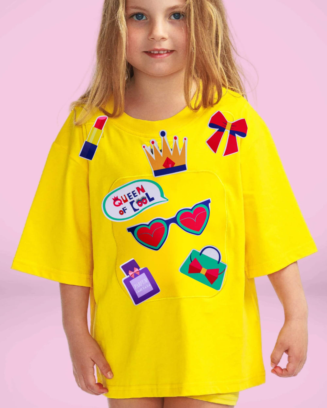 Girl wearing a yellow TeeBoo™ interactive kids T-shirt with the Queen of Cool BooPatch™ gift-ready set for creative screen-free play.