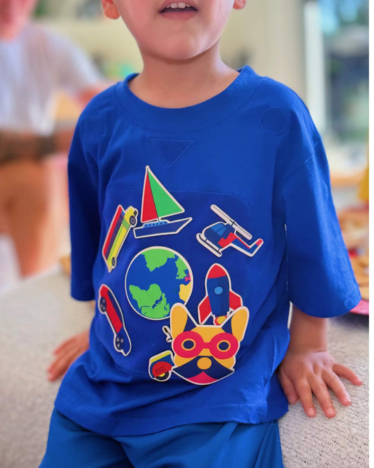 Child wearing a blue TeeBoo™ interactive kids T-shirt with the SpeedyBoo BooPatch™ set for creative screen-free play.